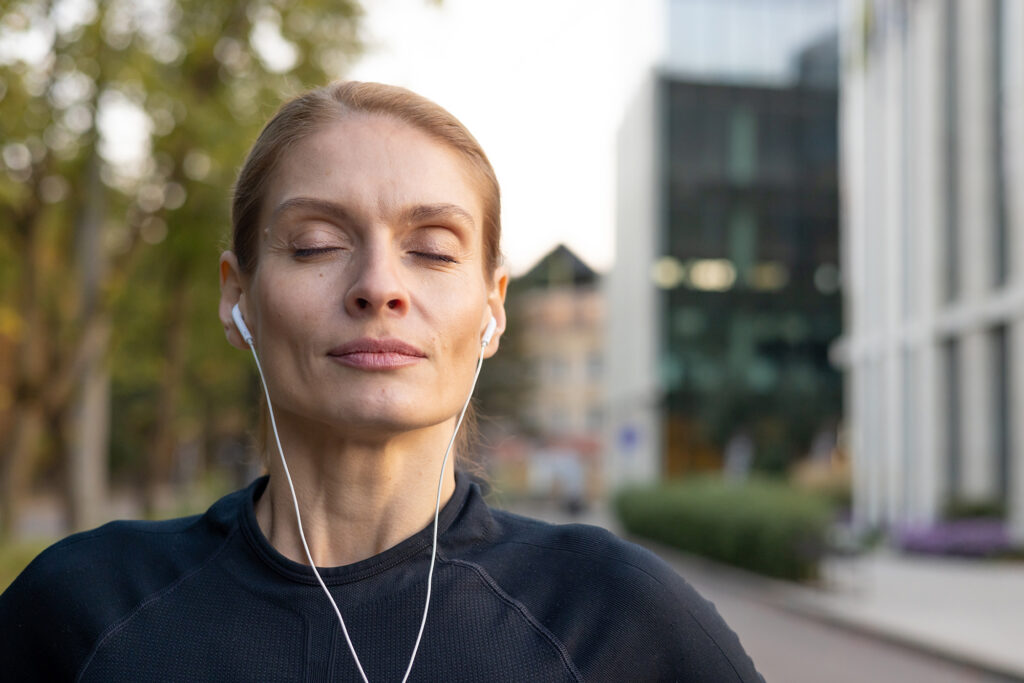Comprehensive Care | Signature Precision Package Woman listening to music outdoors.